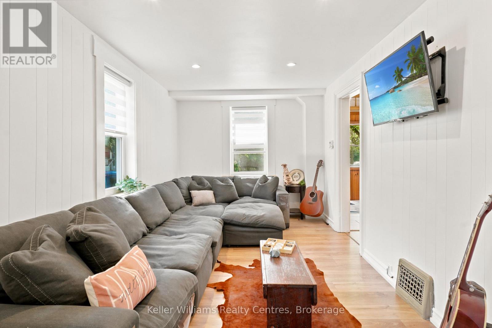 Bright open living room with sectional sofa and new laminate floors