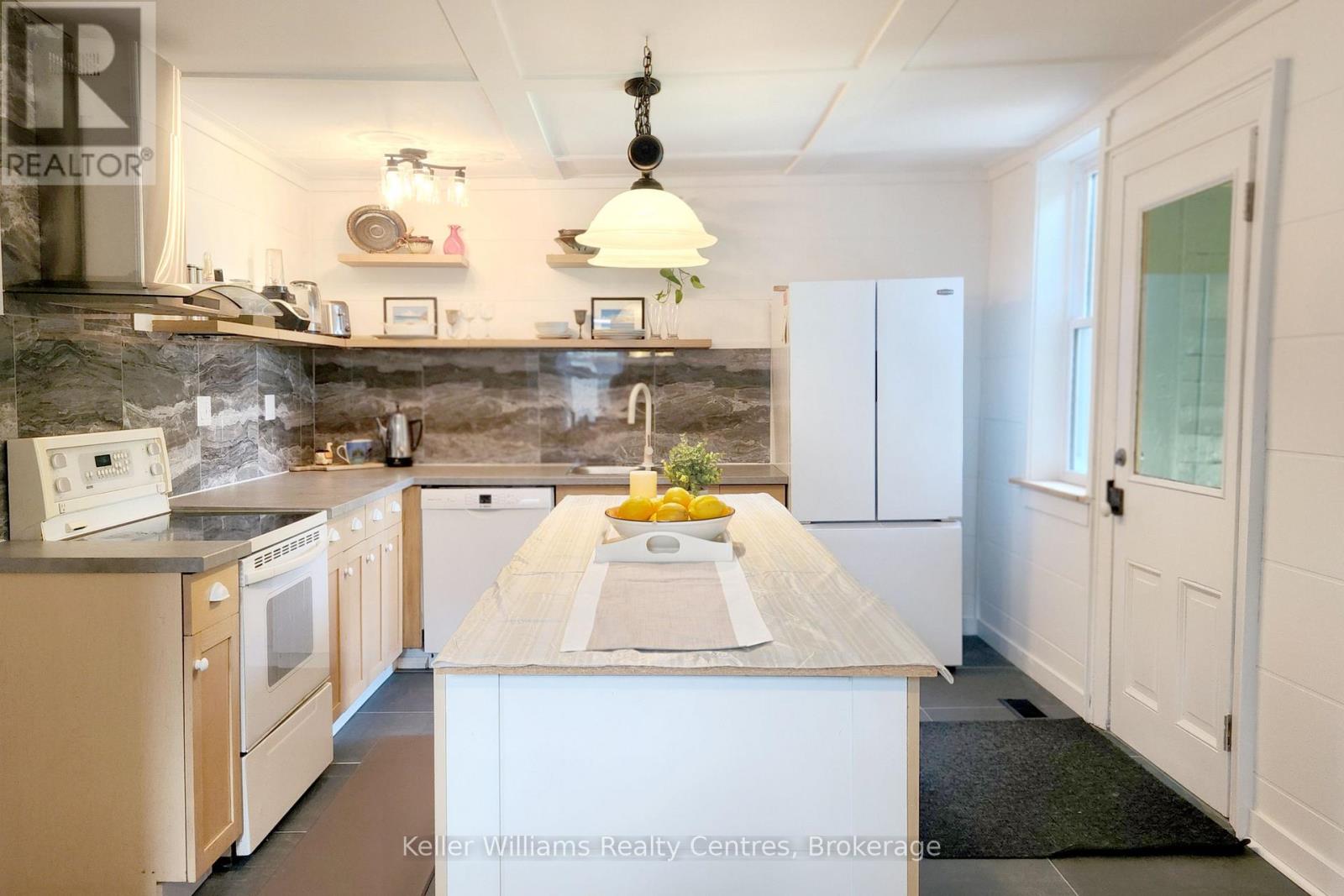 Updated white kitchen with butcher-block island and ceramic tile floor