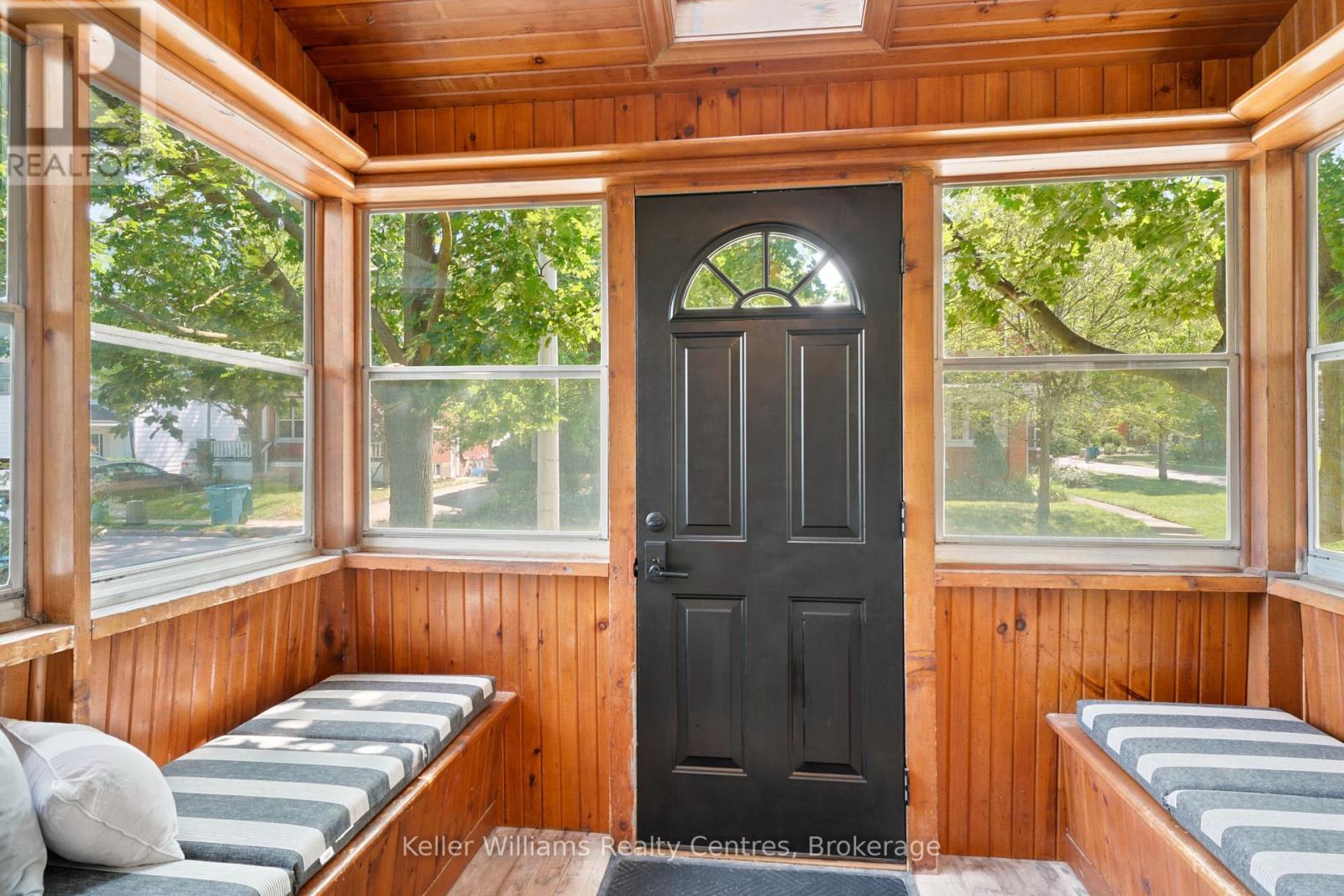 Enclosed front sunroom with wood ceiling and window benches